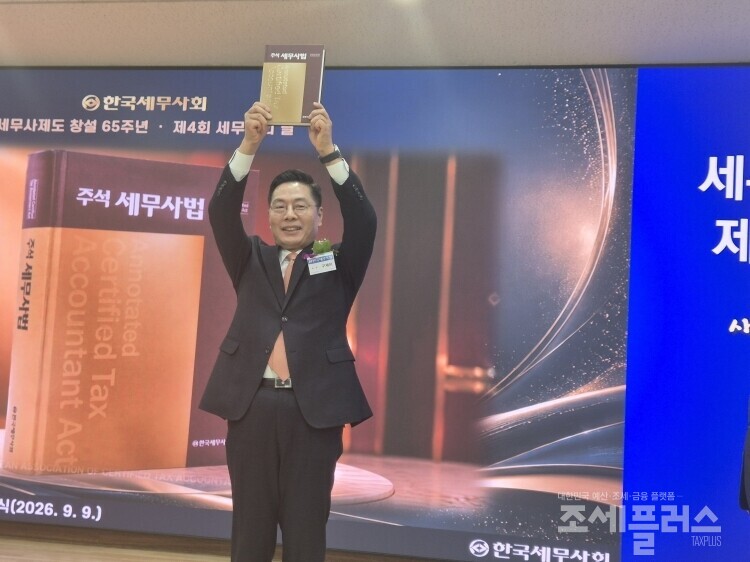 구재이 한국세무사회장이  ‘세무사제도 창설 65주년 및 제4회 세무사의 날 기념식’에서  전달받은「주석세무사법」을 높이 들어 회원들에게 선보이고 있다. 