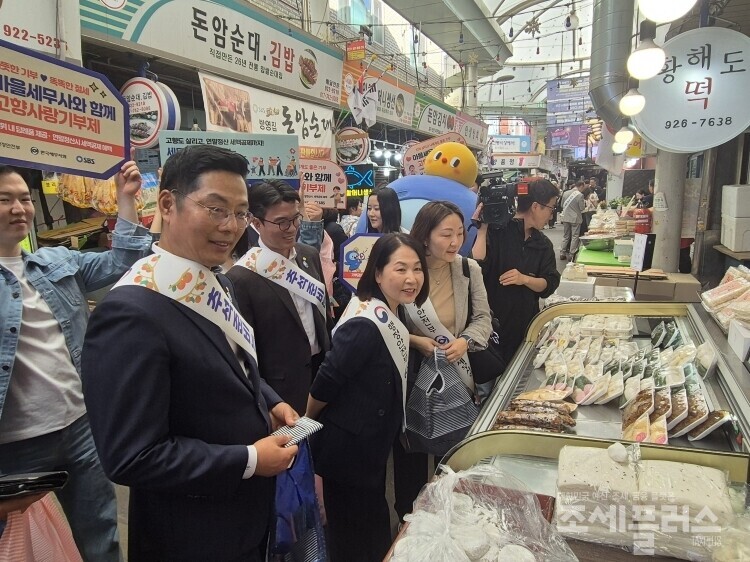 송경주 행안부 지방재정경제실장과 한국세무사회 구재이 회장, 김선명 부회장 등이 돈암전통시장에서 물품을 구입하며 상인과 대화를 나누고 있다.
